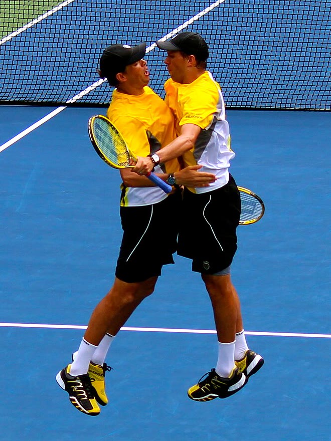 Bob and Mike Bryan mid-air in a chest bump on court at the US Open.
